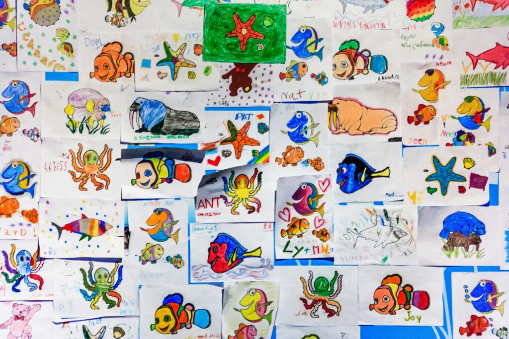pexels photo 998067 998067 1 A colorful collage of children's drawings featuring various marine life in vibrant hues.